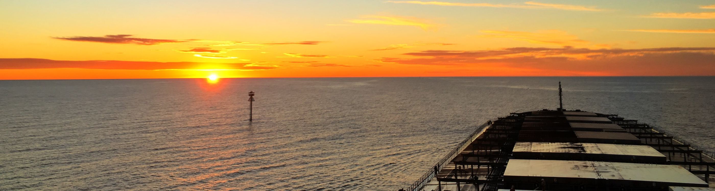 Sunset over the pilot boarding ground from the bow of a bulk carrier